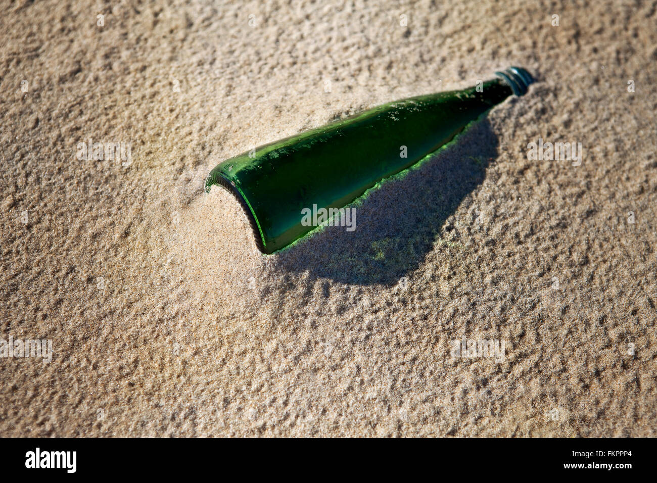 Old glass bottle stranded on the sand of the beach after the tide Stock Photo