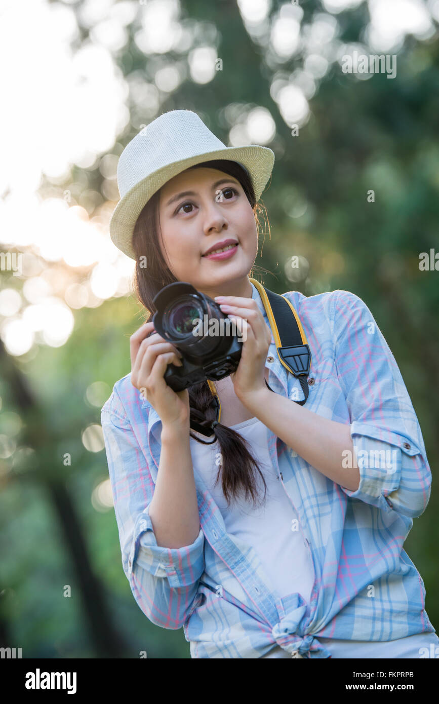 Beautiful asian girl smiling with digital camera photographing, outdoor