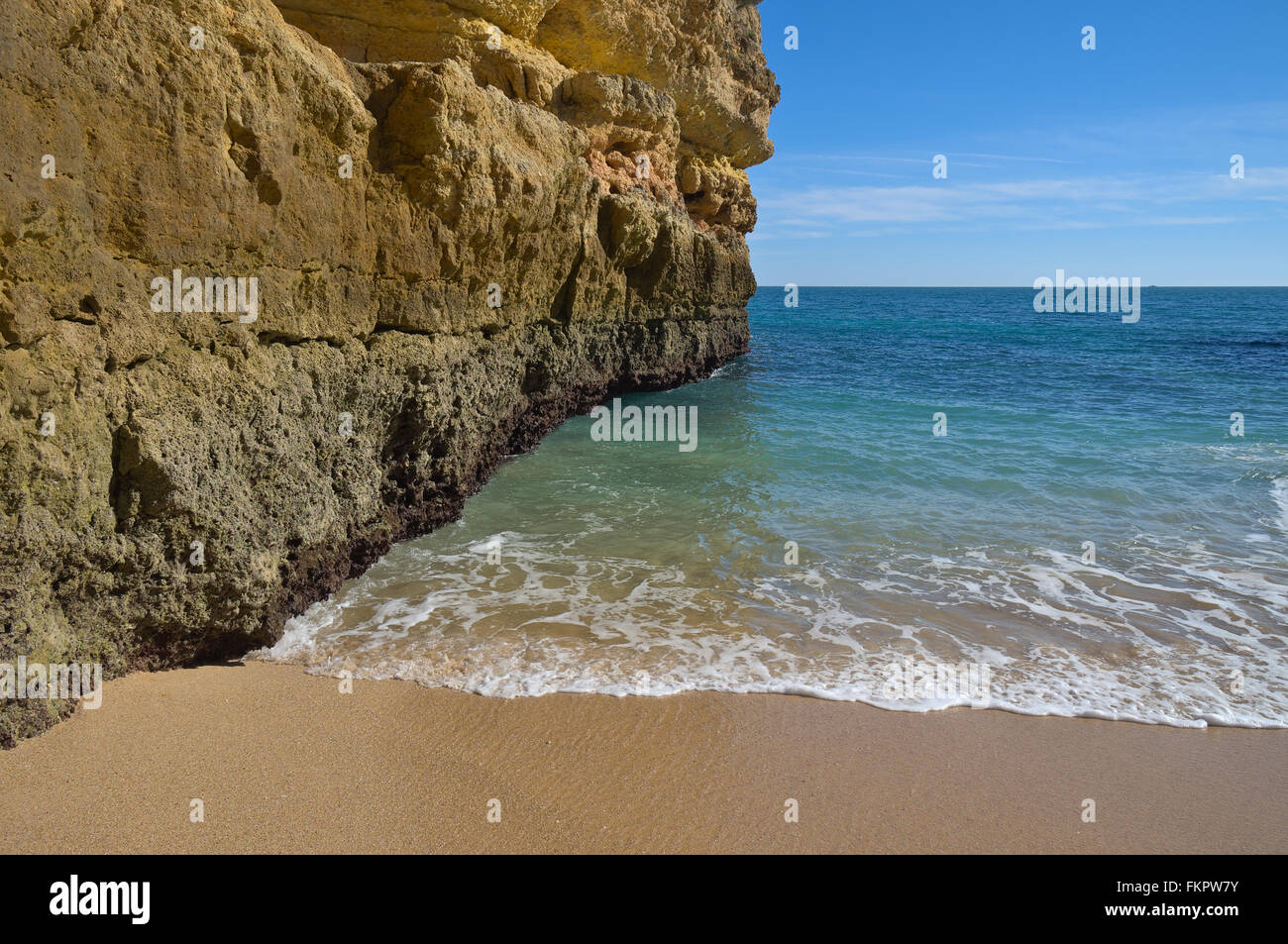 Beach waves lightly touching the sands in Fontainhas beach. Algarve
