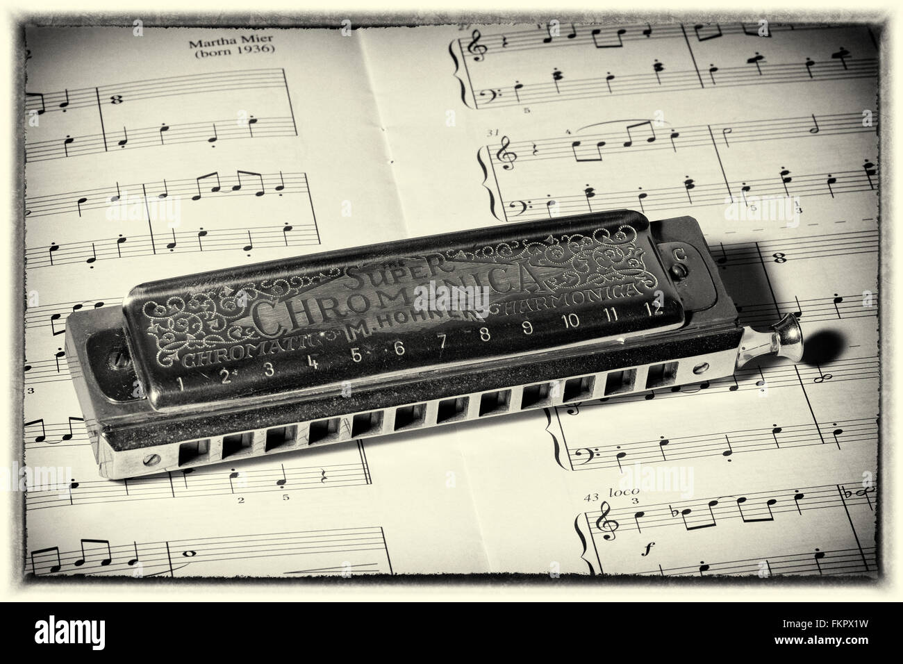 still life of Hohner harmonica on sheet music Stock Photo