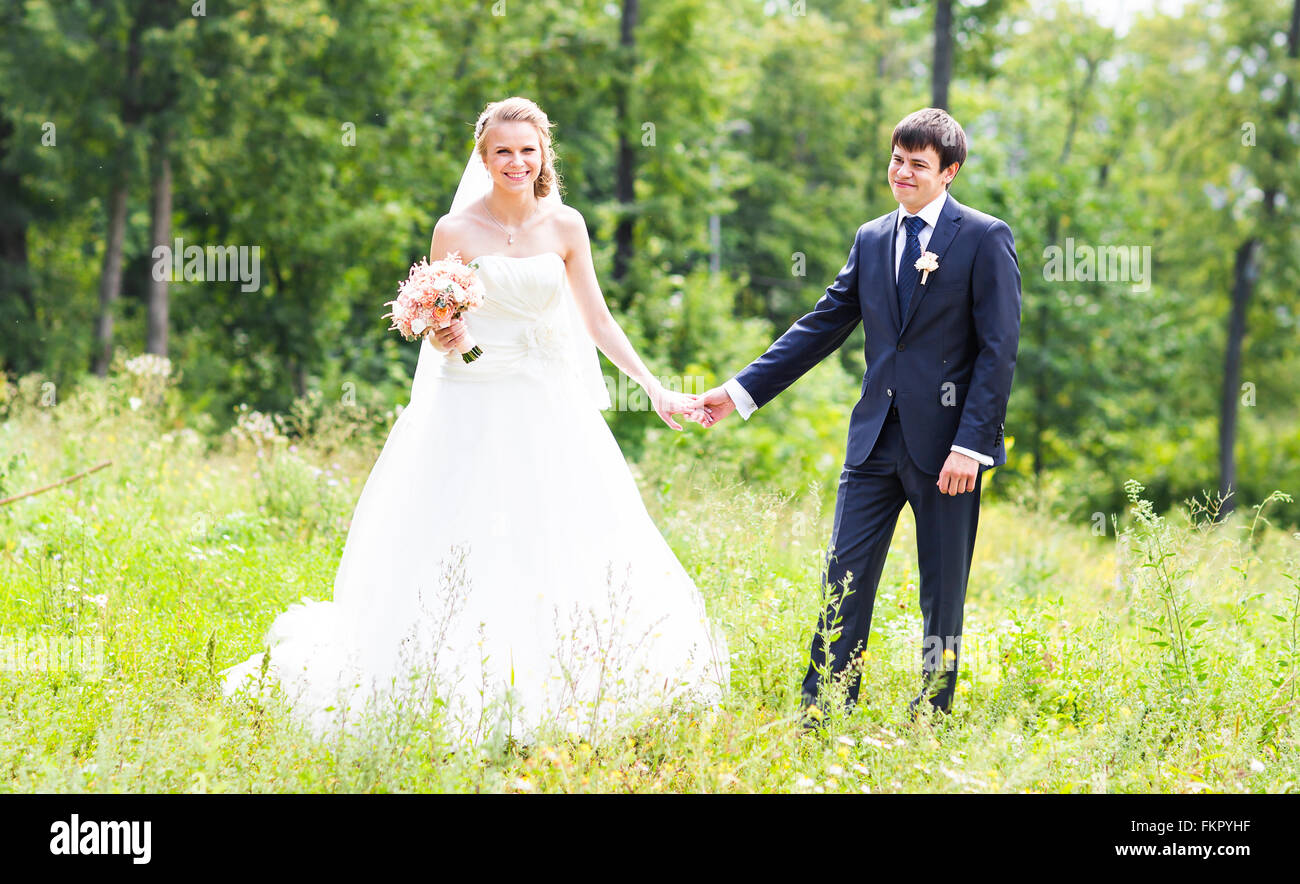 Bride and groom holding hands outdoors Stock Photo - Alamy