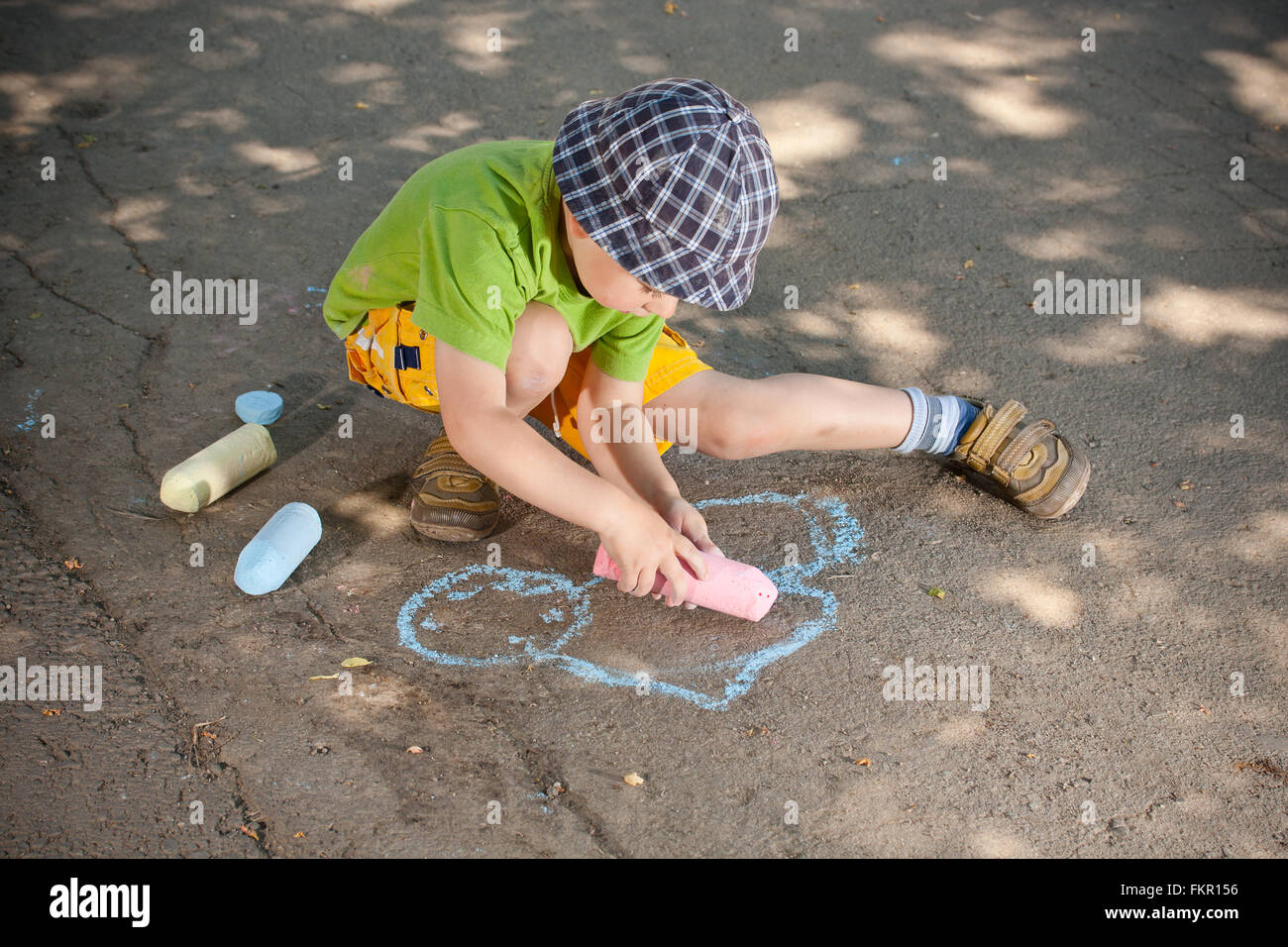 Boy drawing with chalk on asphalt Stock Photo - Alamy