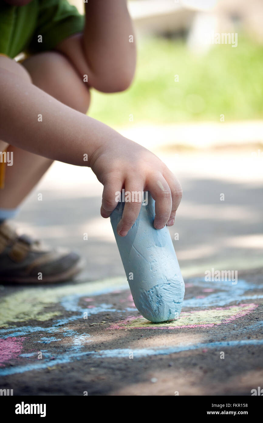 Boy drawing with chalk on asphalt Stock Photo - Alamy