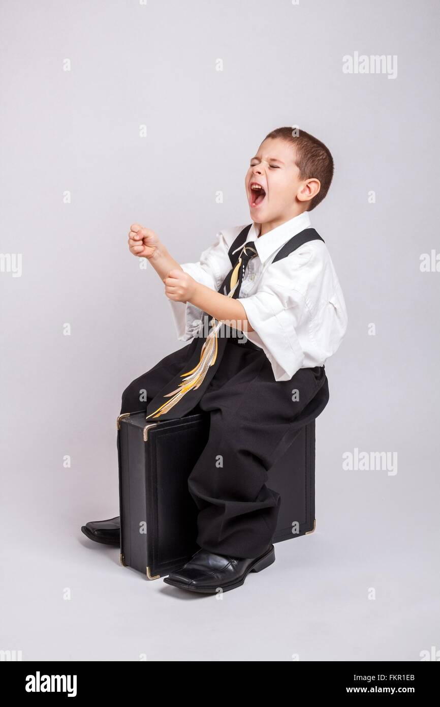 Happy driving business boy sitting on a briefcase, leads to success Stock Photo