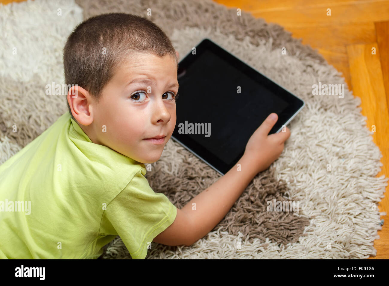 Little boy lying on floor and using digital tablet Stock Photo - Alamy