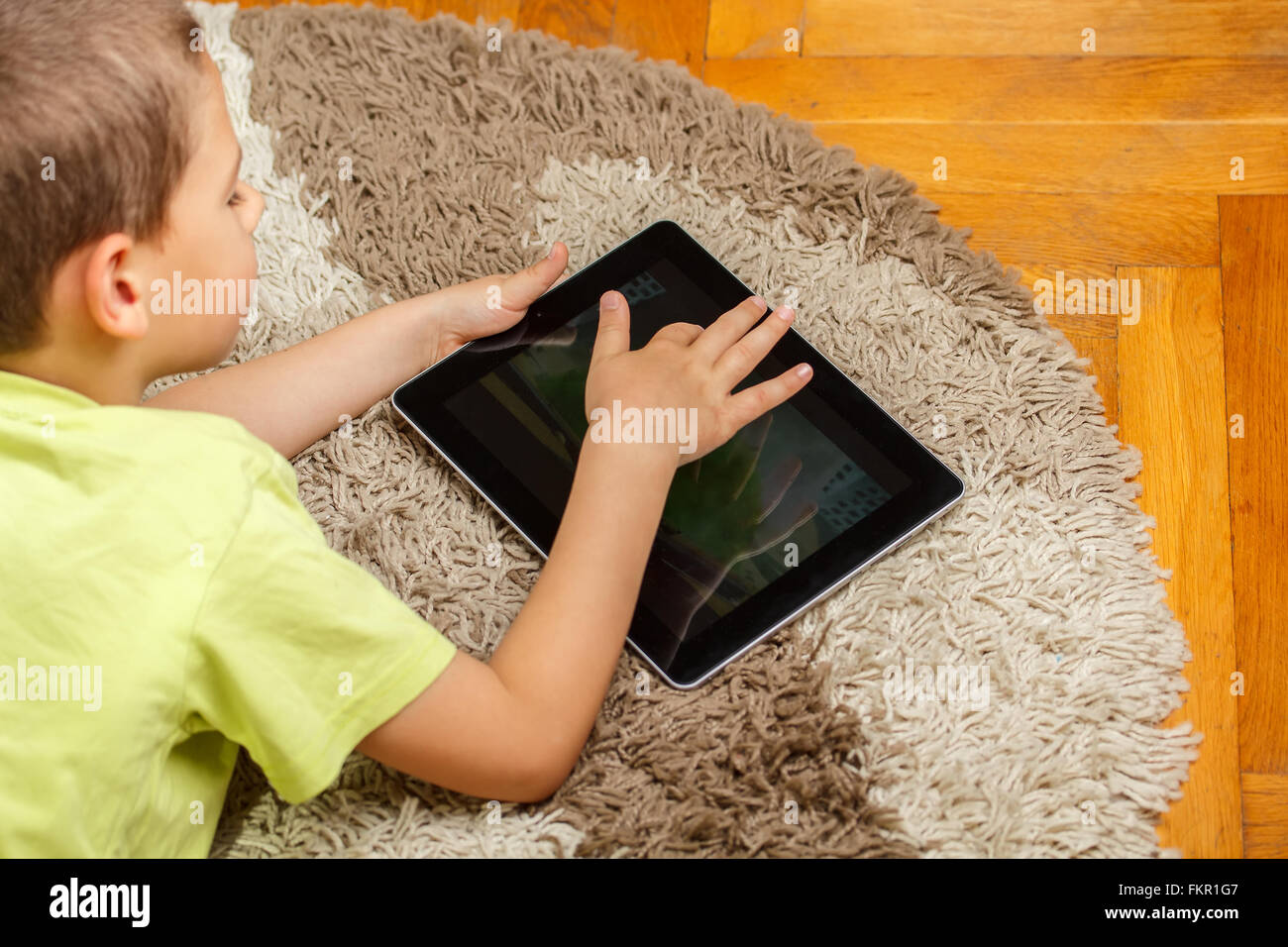 Young kid playing with tablet pc Stock Photo