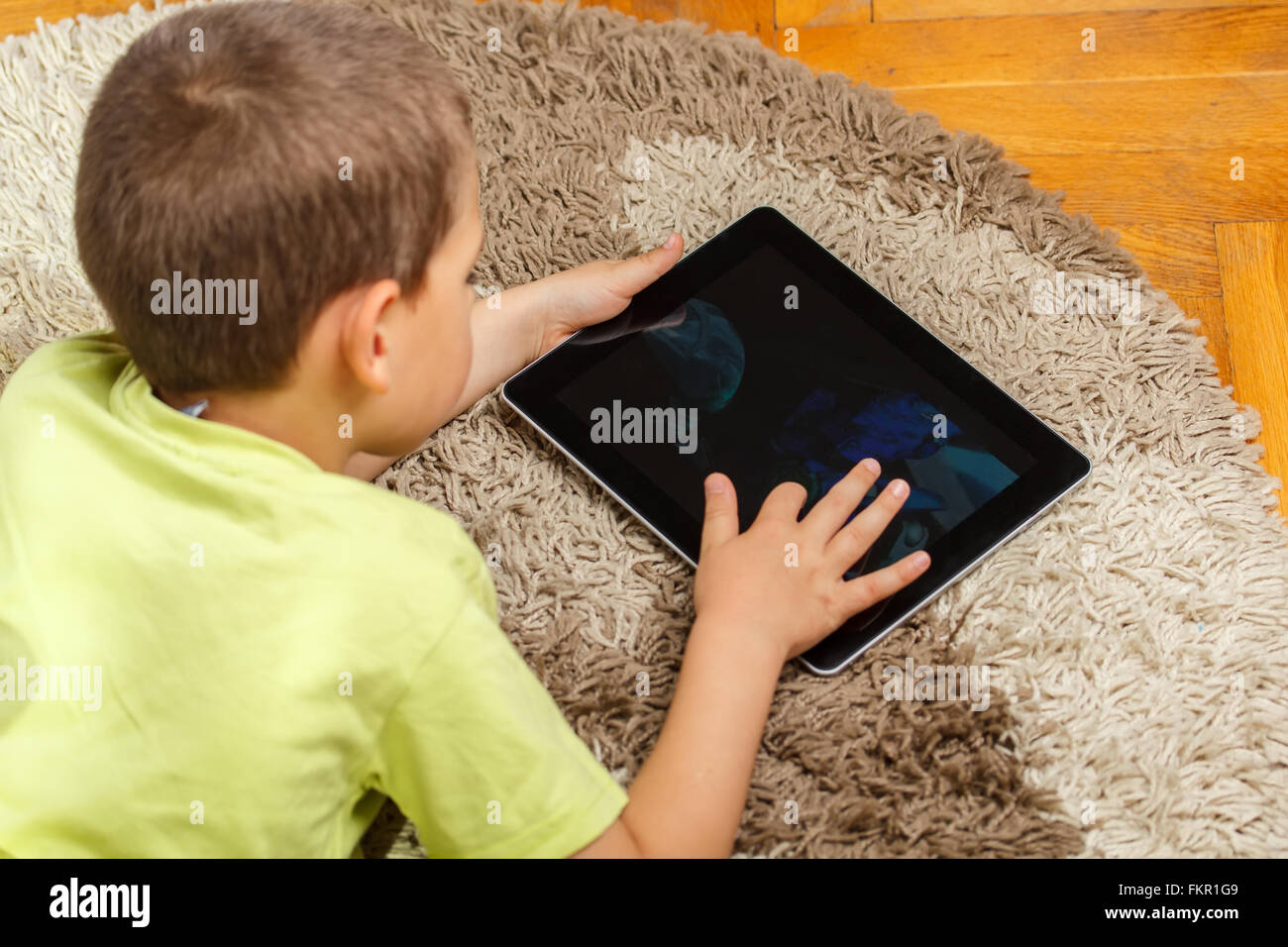 Little boy lying on floor and using digital tablet Stock Photo - Alamy