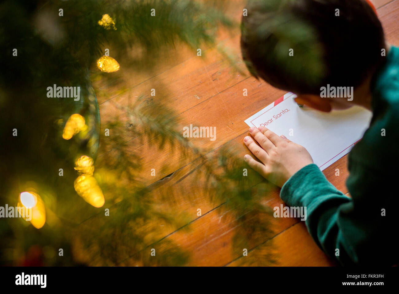 Mixed race boy writing letter to Santa Stock Photo