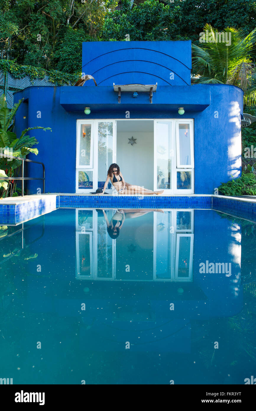 Mixed race woman reflected in swimming pool Stock Photo