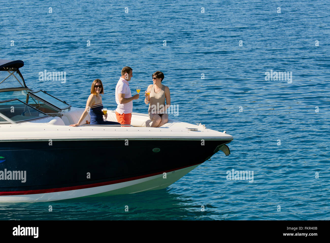 Friends relaxing on boat in ocean Stock Photo