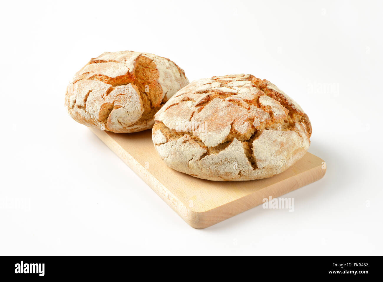 two fresh loaves of bread on wooden cutting board Stock Photo - Alamy