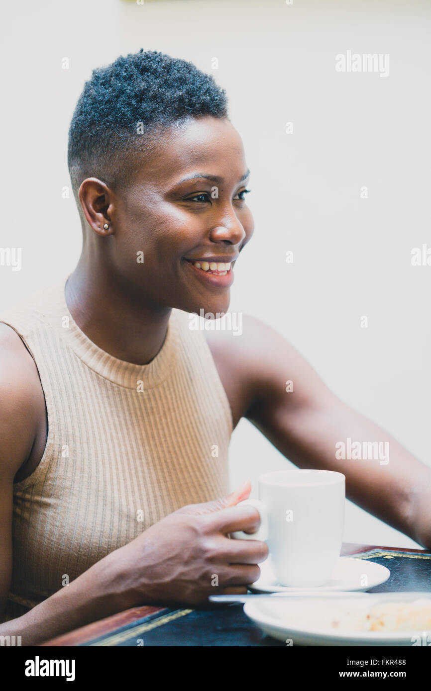 Black woman drinking coffee in cafe Stock Photo