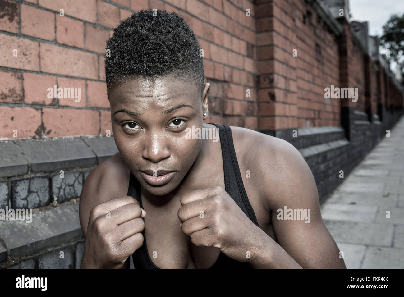 Black athlete with fists raised outdoors Stock Photo