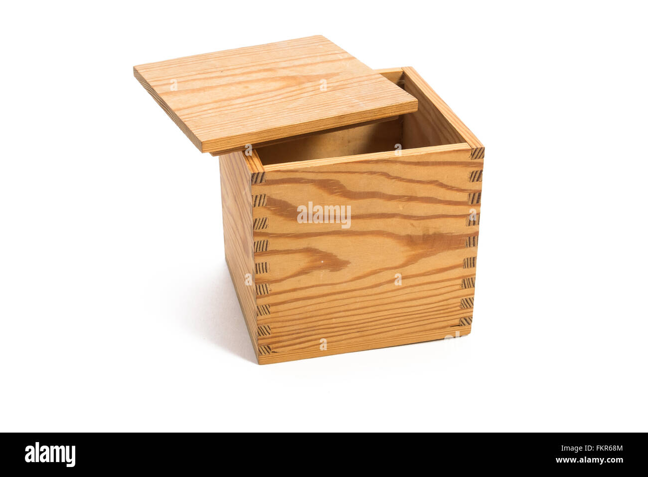 Empty wood box made with finger joints with the opening facing up and the lid lying on top, covering half the opening Stock Photo