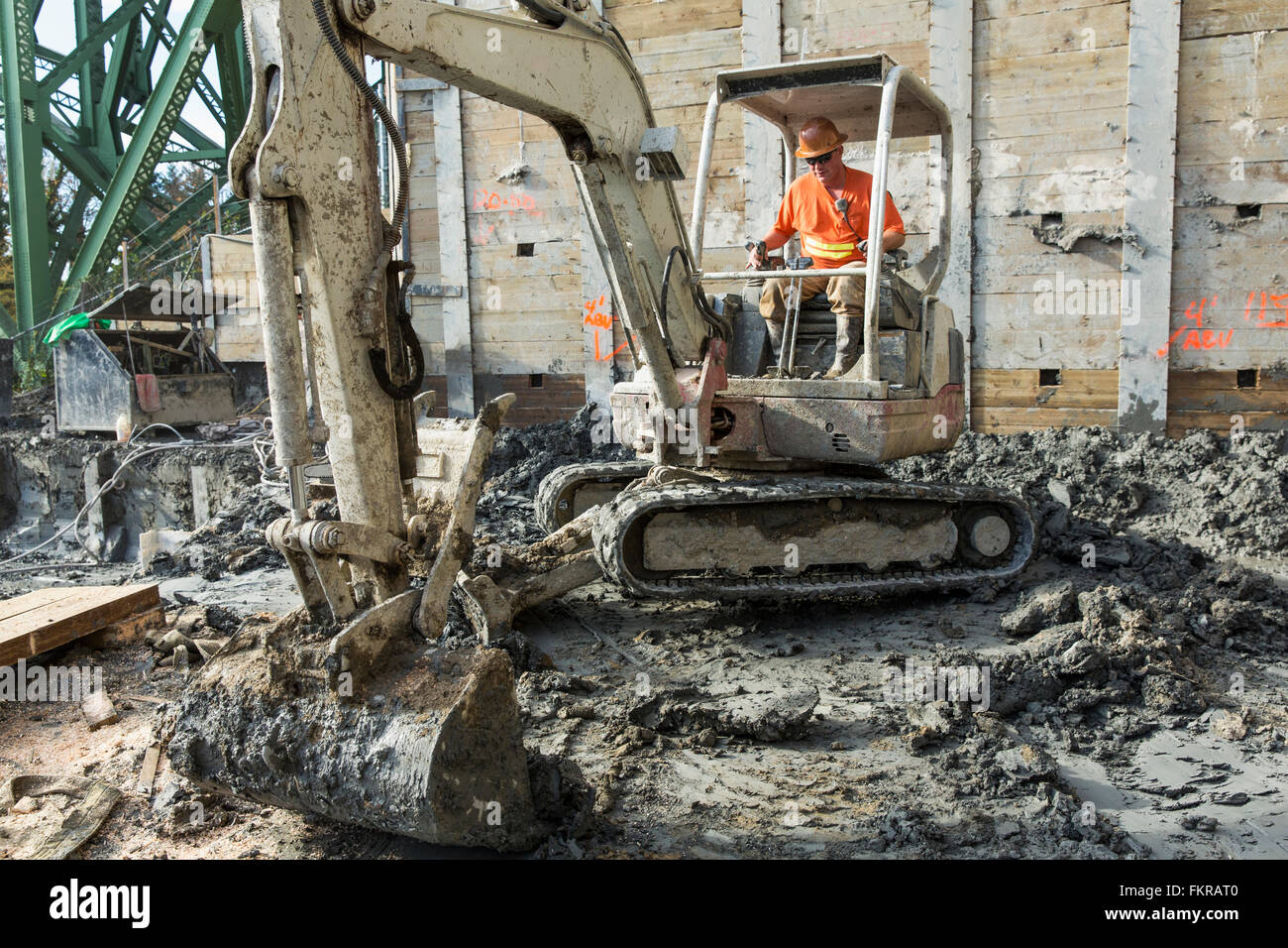 Caucasian worker using digger at construction site Stock Photo