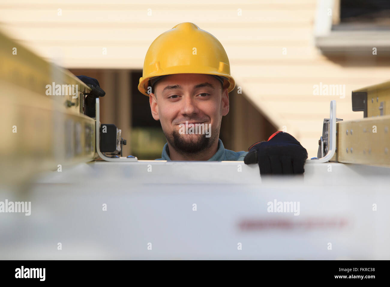 Caucasian installer pulling ladder from truck roof Stock Photo Alamy