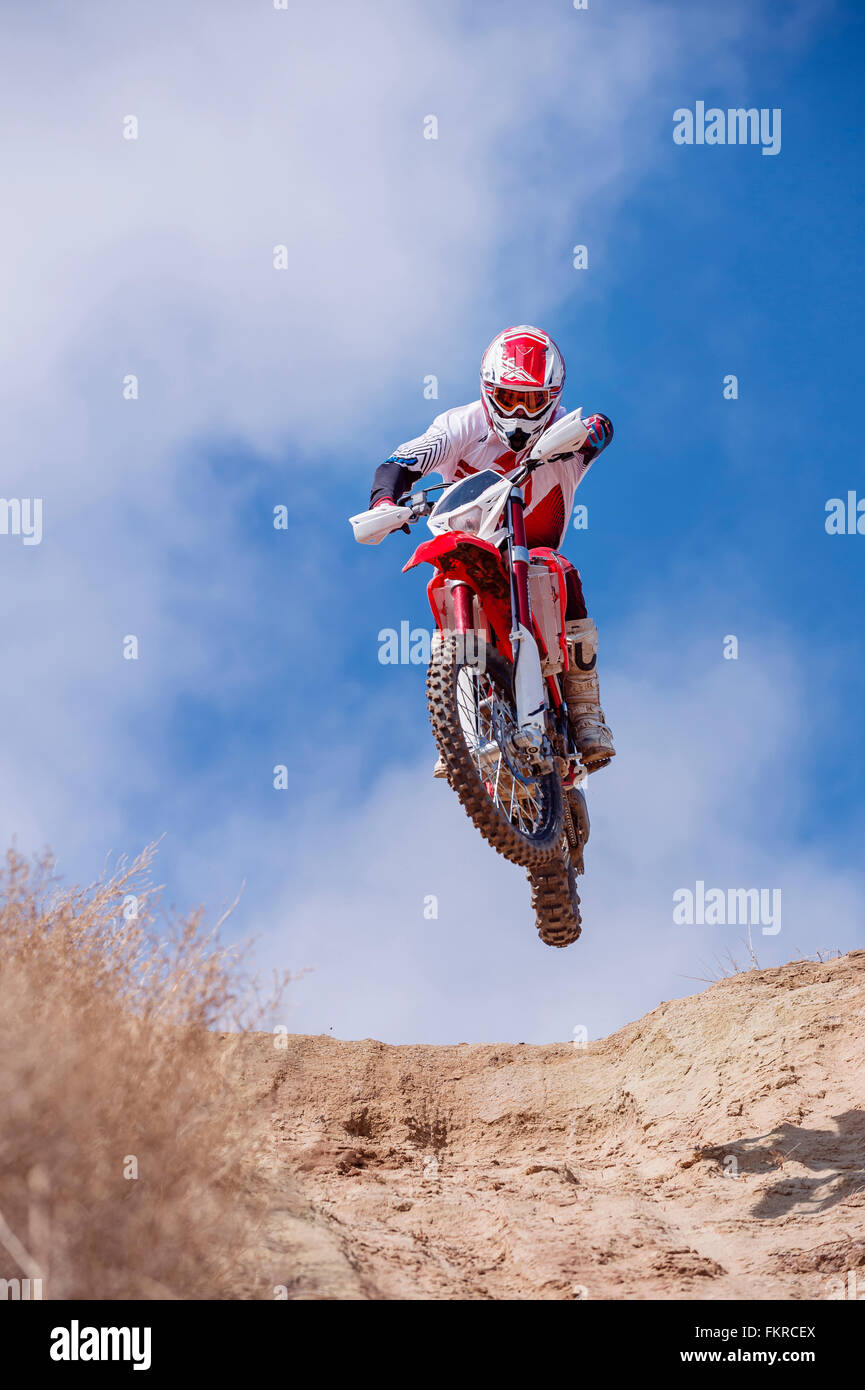 Motorcyclist riding dirt bike on hillside Stock Photo