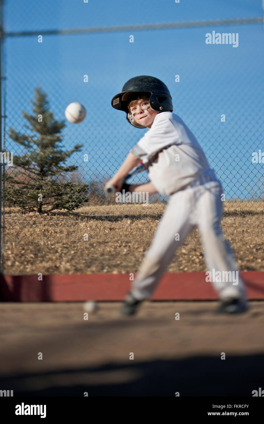 Caucasian boy hitting baseball on field Stock Photo Alamy