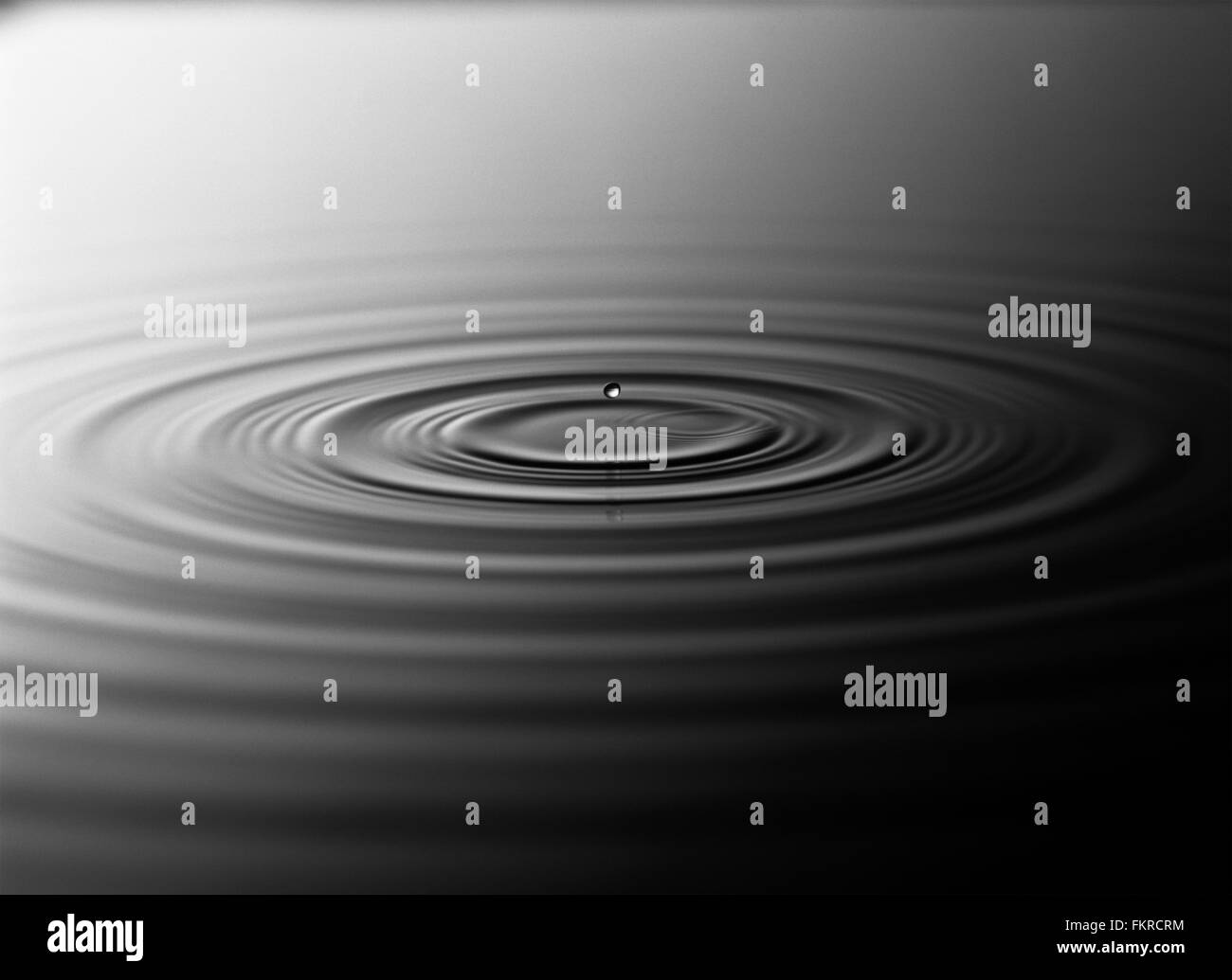 Droplet splashing in rippling water Stock Photo Alamy