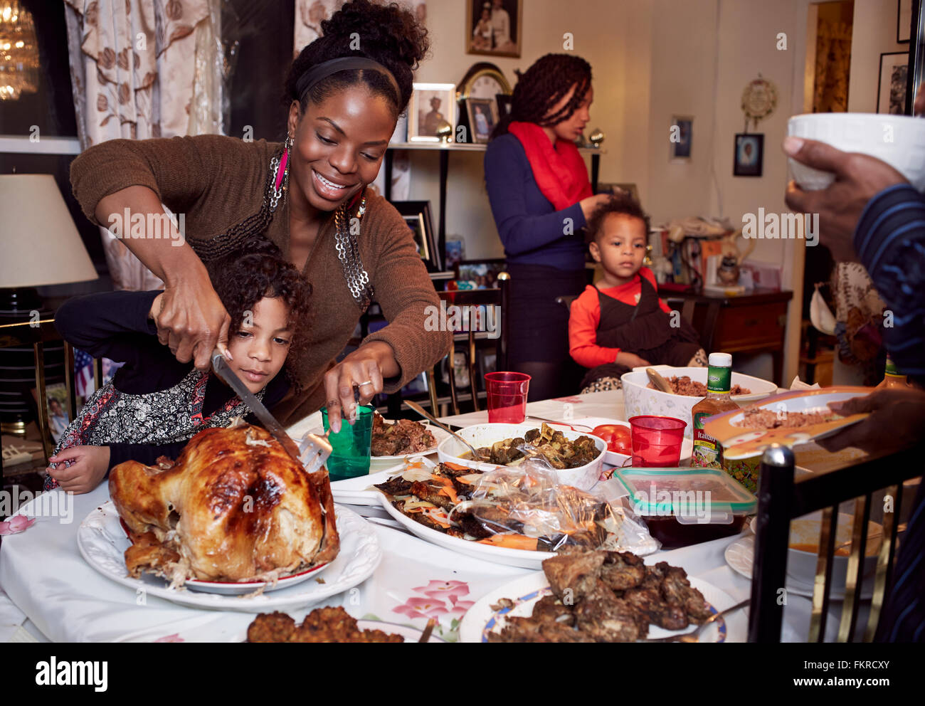 Mother and daughter carving turkey at holiday dinner Stock Photo