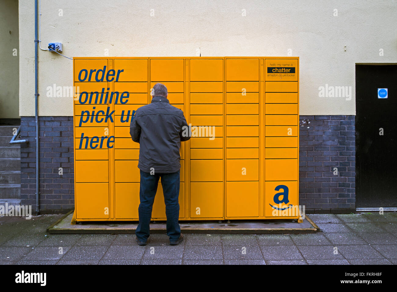 A man collecting a parcel from an Amazon collection point in Edinburgh. Stock Photo