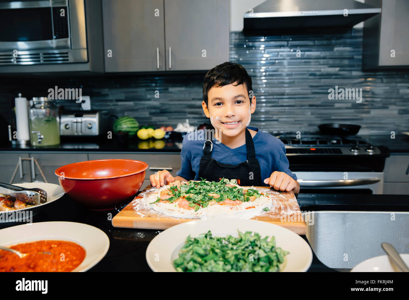 Mixed race boy cooking in kitchen Stock Photo