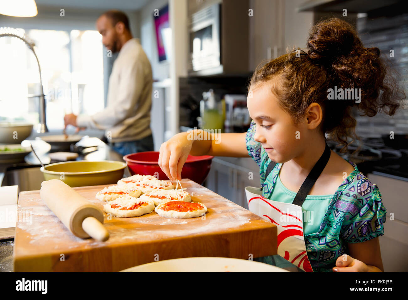 Mixed race girl cooking in kitchen Stock Photo