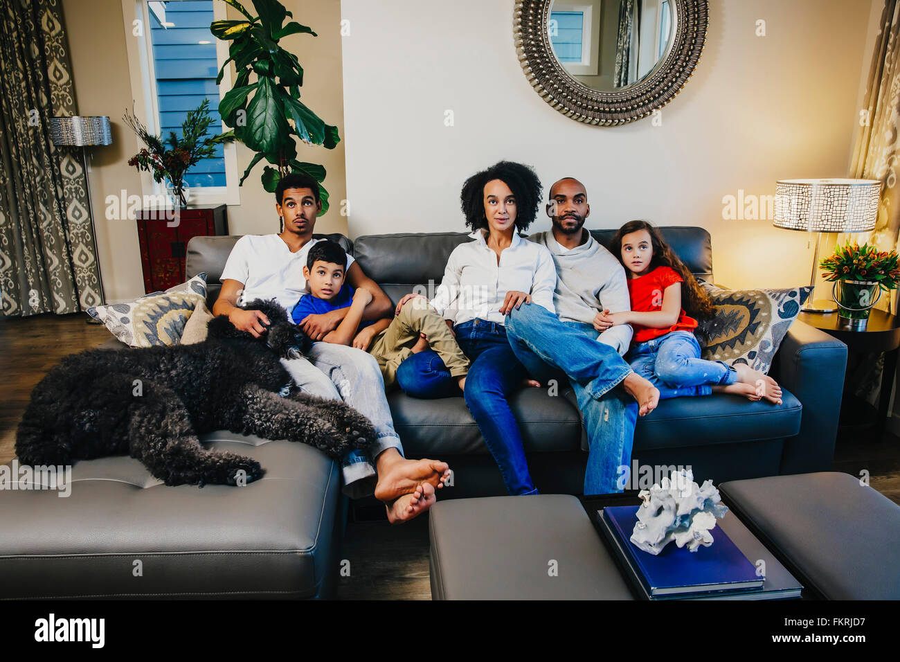 Family watching television on sofa Stock Photo