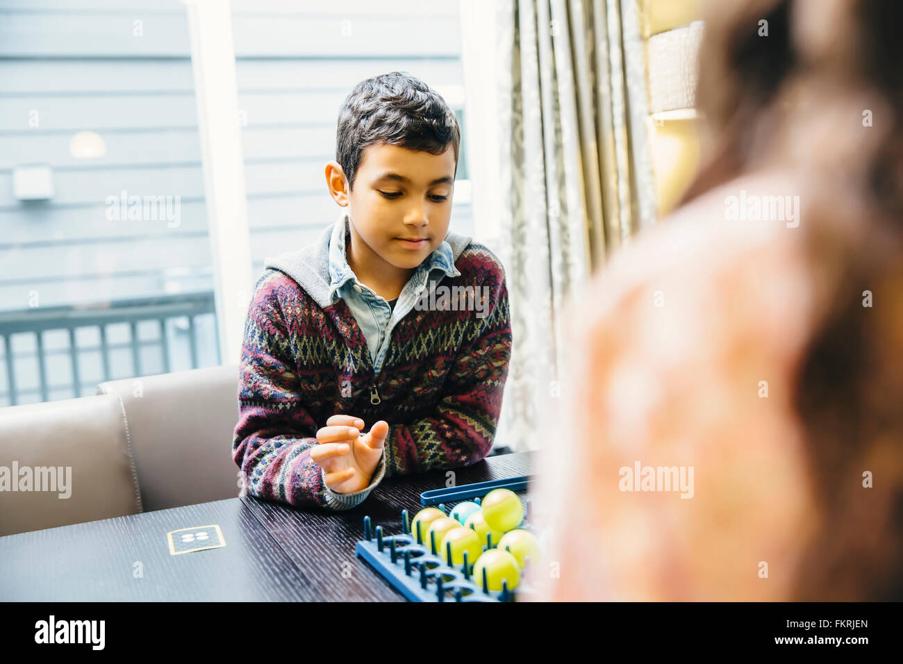 Mixed race siblings playing board game Stock Photo Alamy