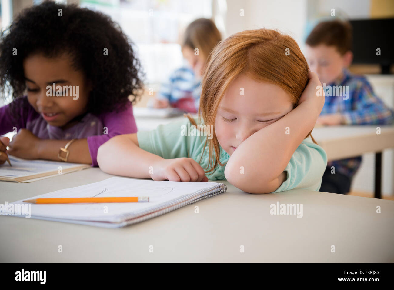 Frustrated student working in classroom Stock Photo