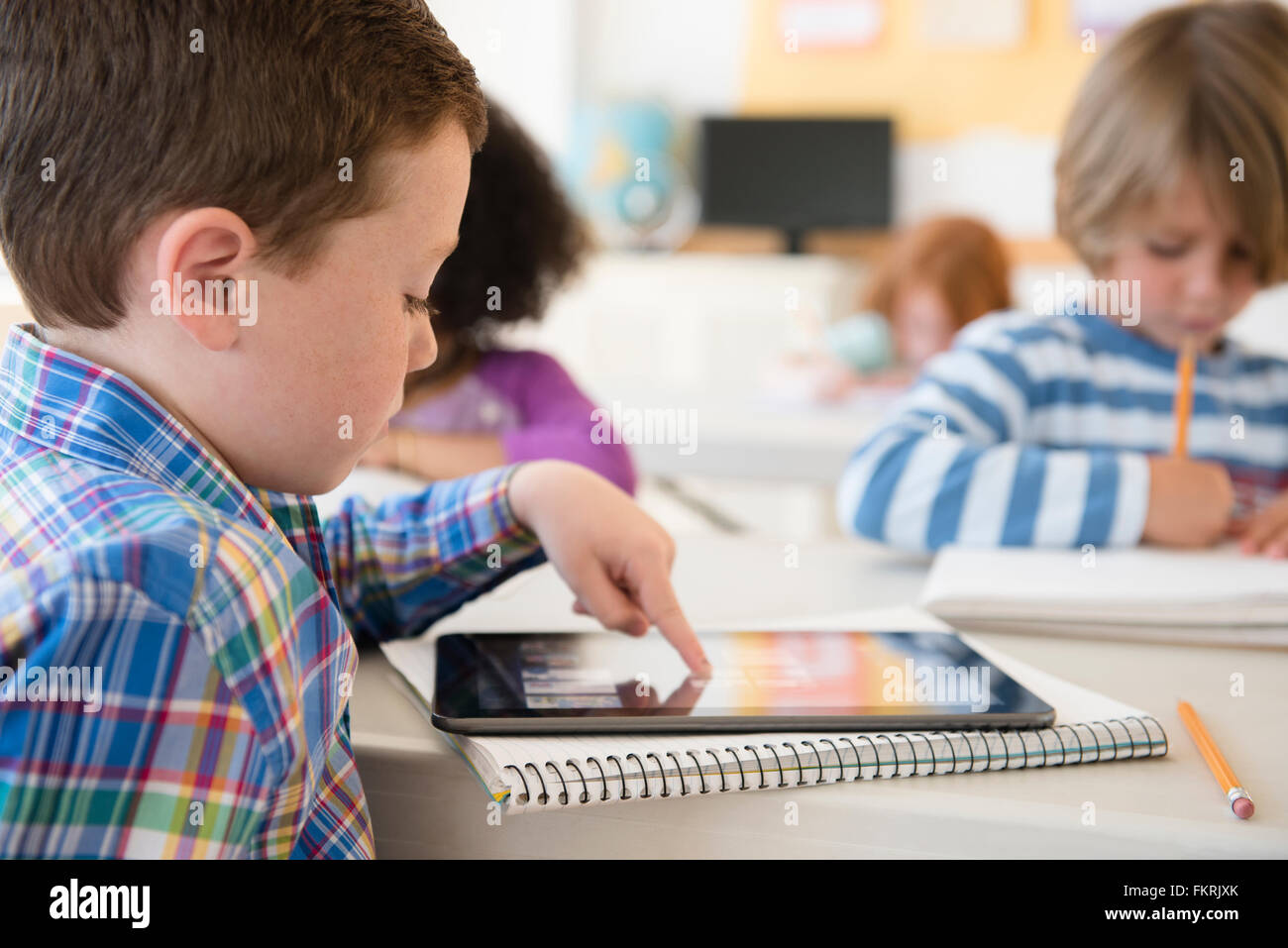 Student using digital tablet in classroom Stock Photo