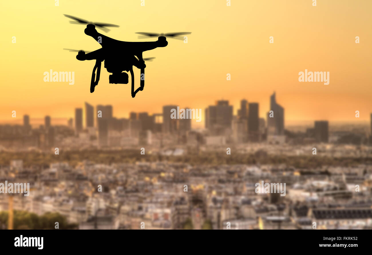 Drone silhouette flying above Paris city panorama Stock Photo