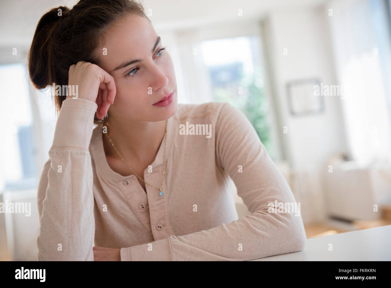 Sad Native American woman sitting at desk Stock Photo