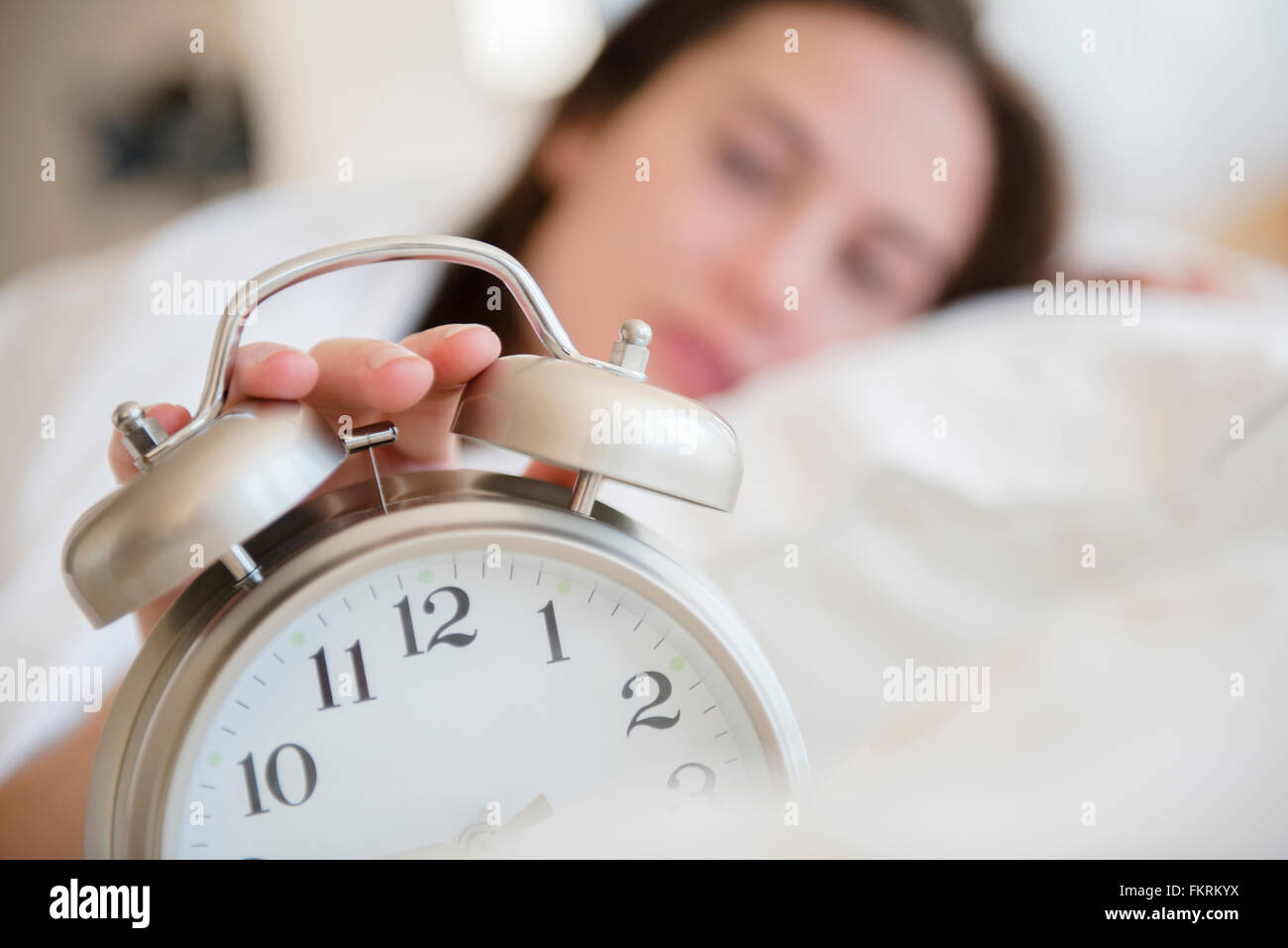 Native American woman turning off alarm Stock Photo