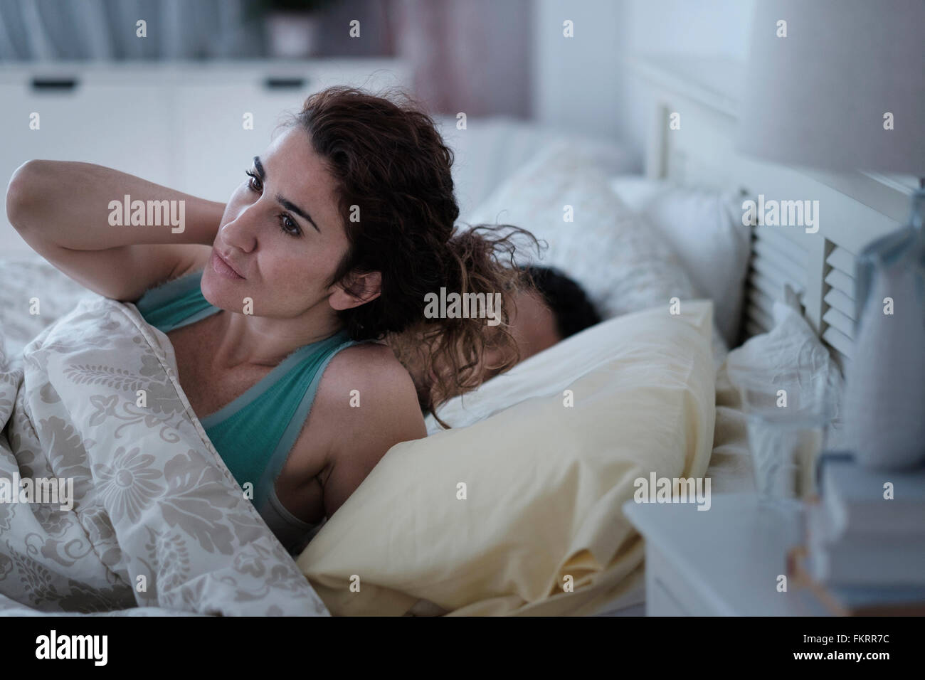 Woman rubbing her neck in bed Stock Photo