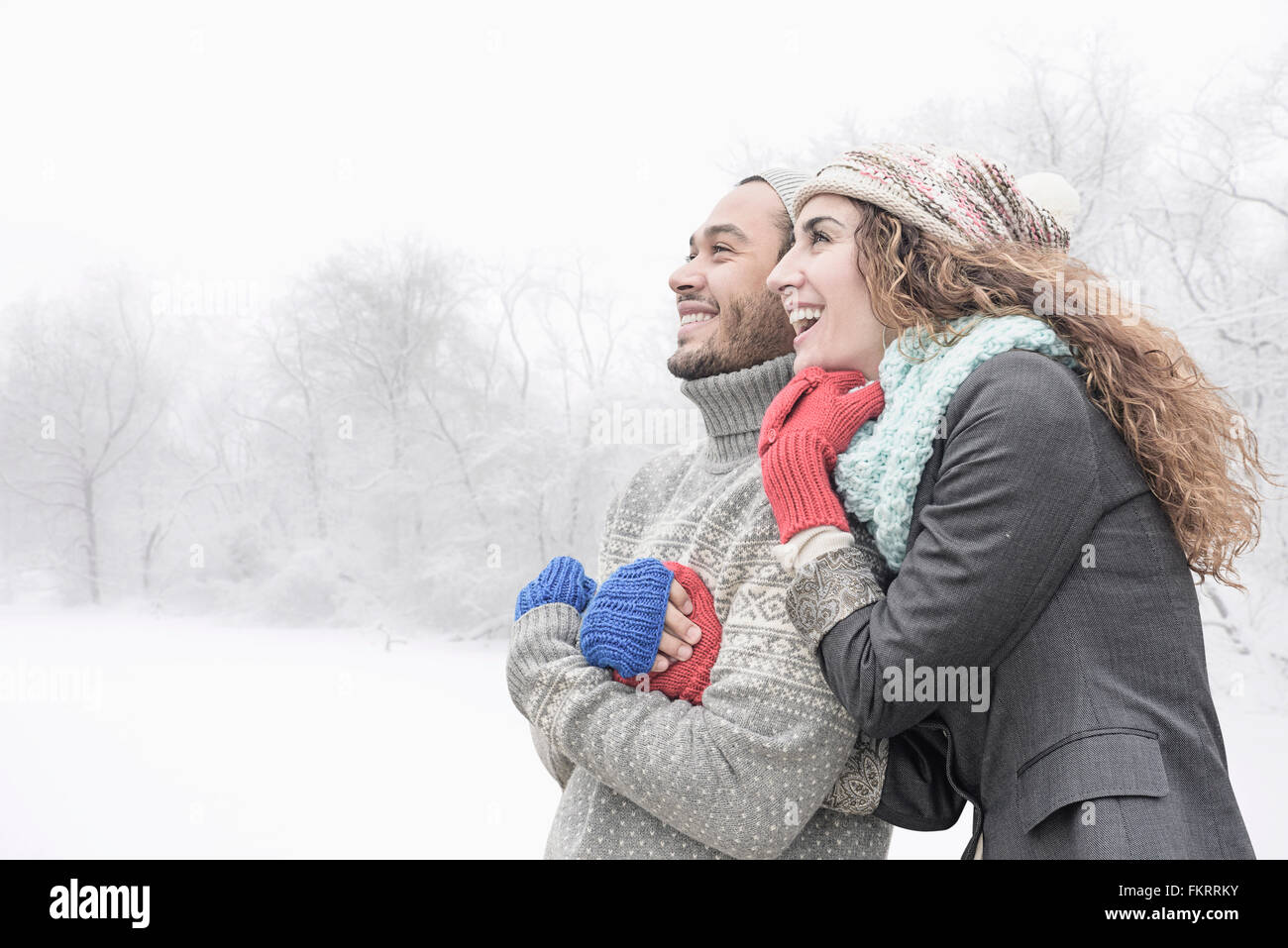 Couple hugging in snow Stock Photo