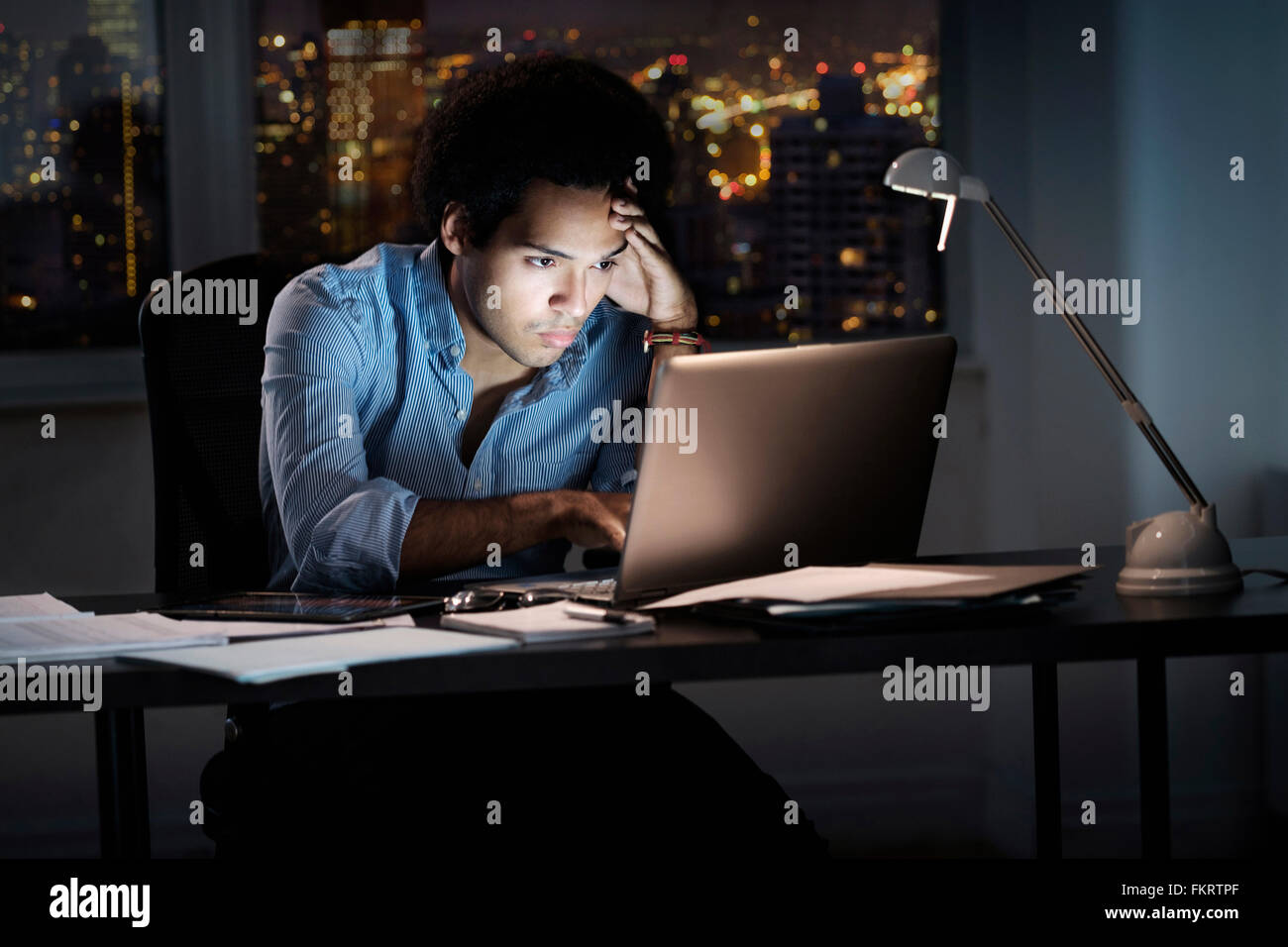 Mixed race businessman working late in office Stock Photo