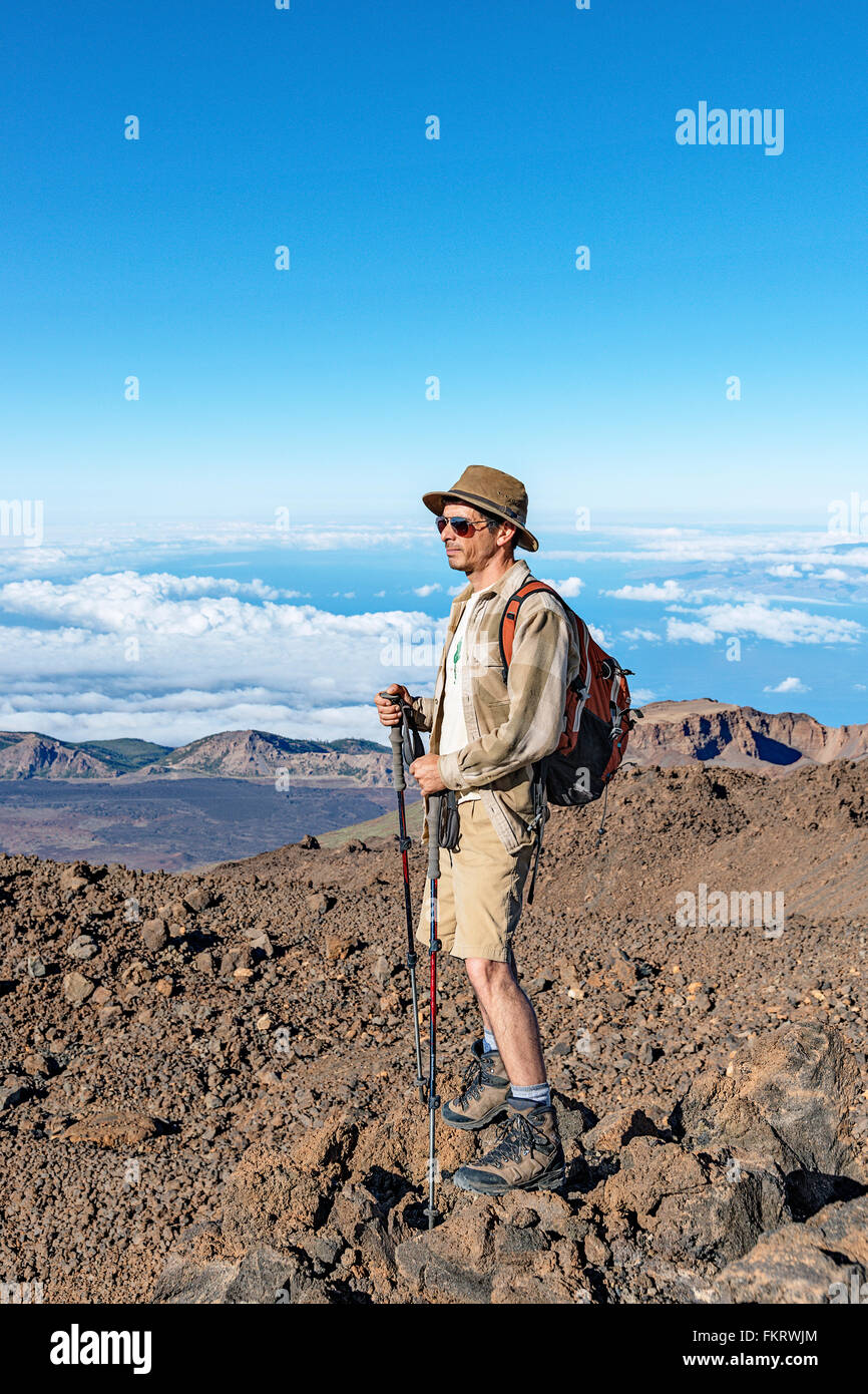 Hiker near the top of Teide volcano (3718 meters above sea level). Crater on the background is called Pico Viejo. Stock Photo