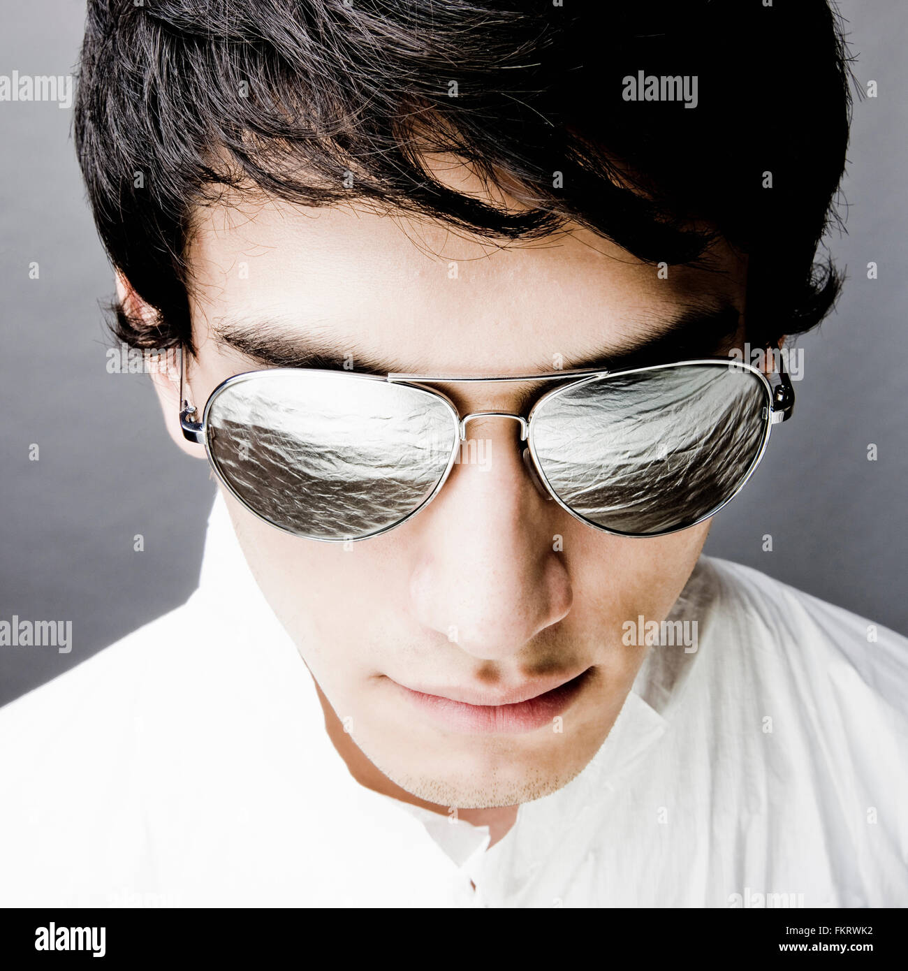 Mixed race man in sunglasses reflecting water Stock Photo