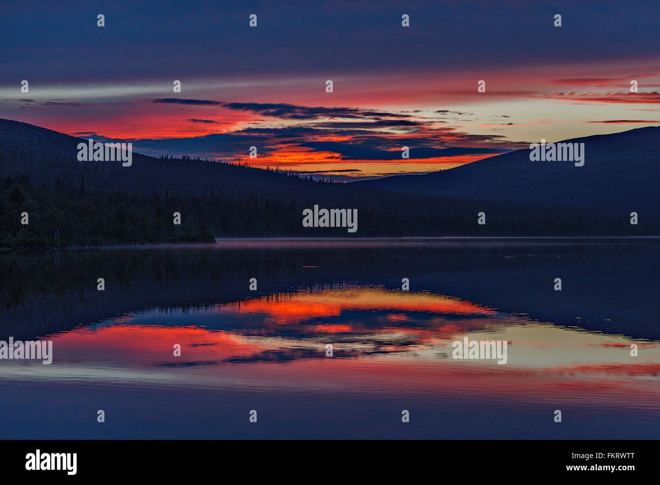 Midnight sun in Luirojärvi lake, Lapland, Finland. Stock Photo