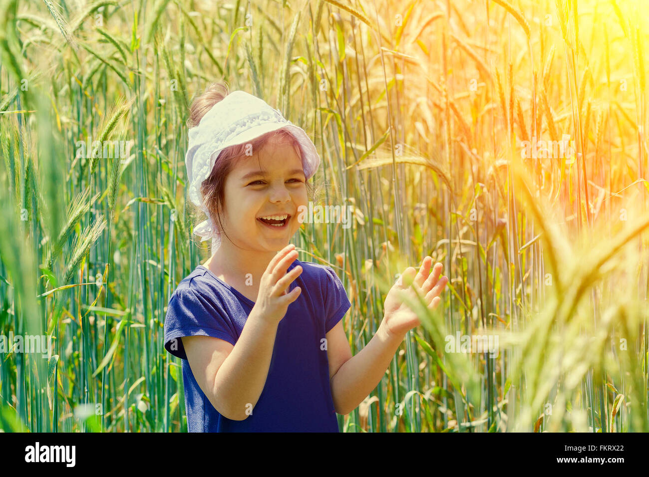 Happy smiling little girl in the wheat field Stock Photo - Alamy