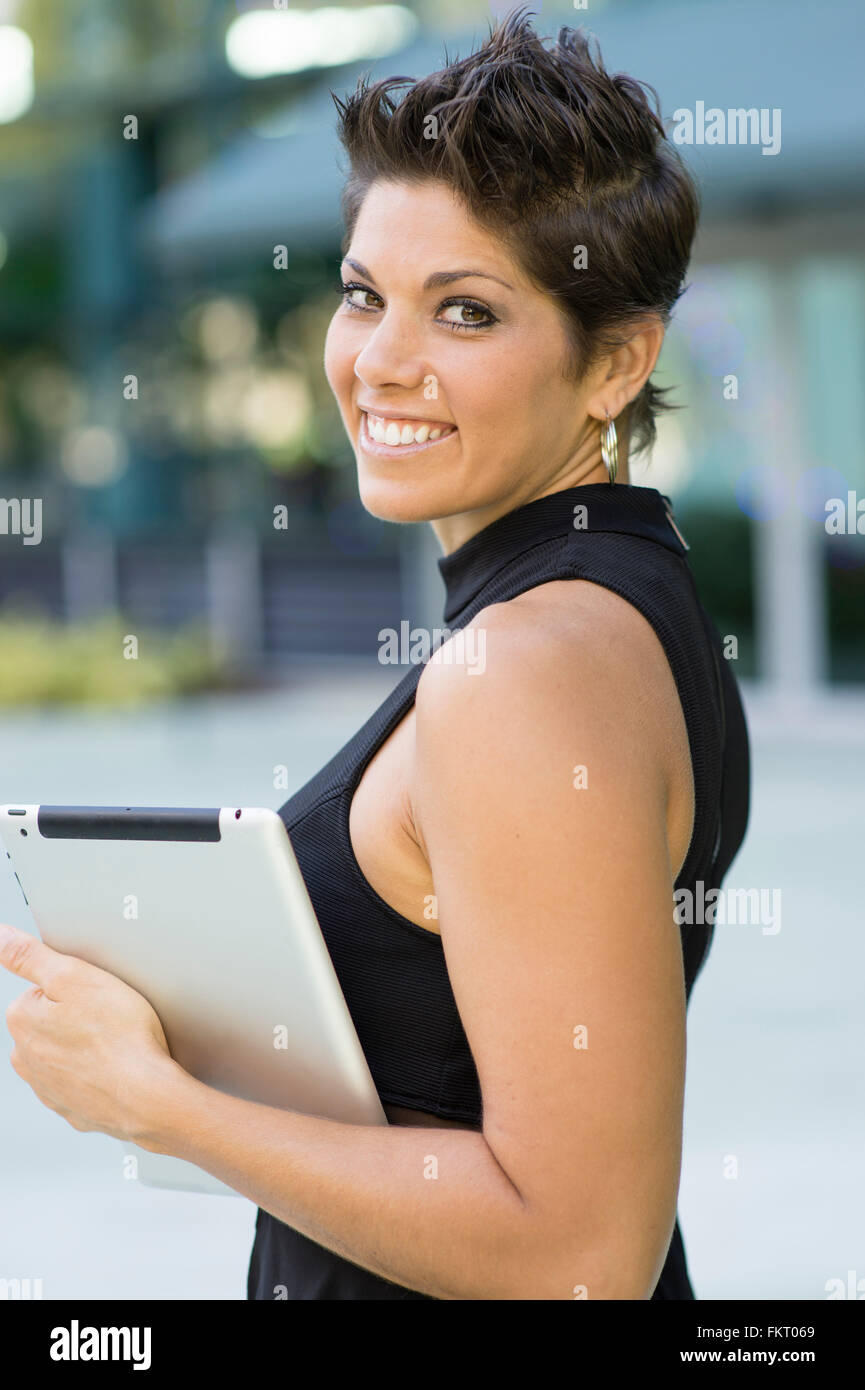 Caucasian woman holding digital tablet outdoors Stock Photo