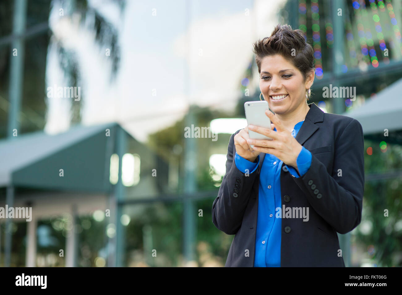 Caucasian businesswoman using cell phone outdoors Stock Photo