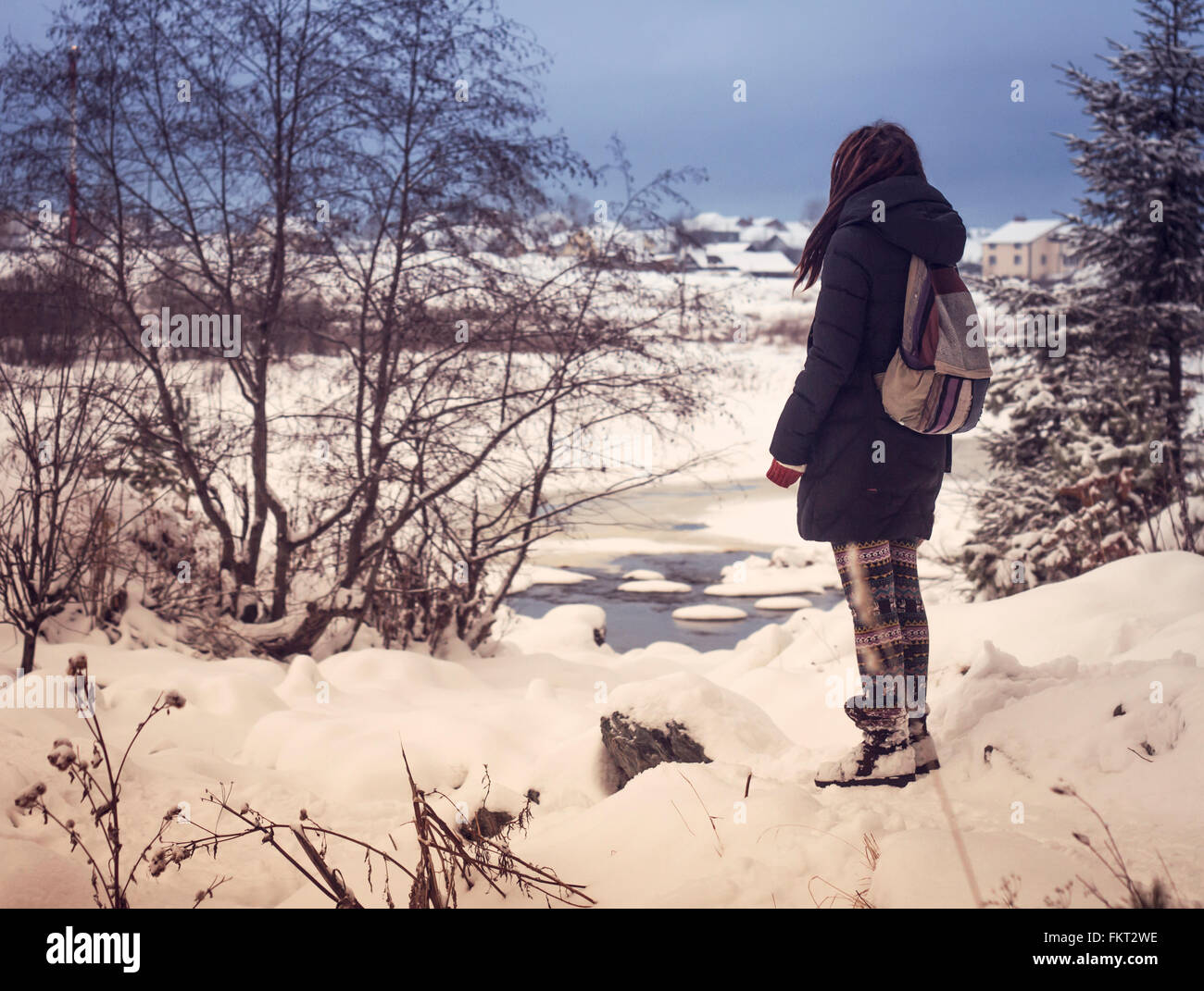 Caucasian woman admiring snowy rural scene Stock Photo