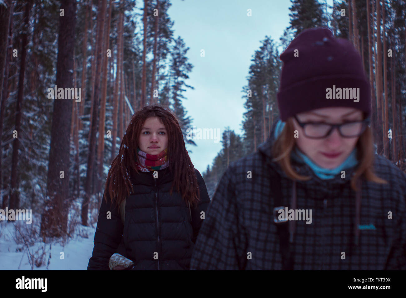 Caucasian women walking in snowy forest Stock Photo