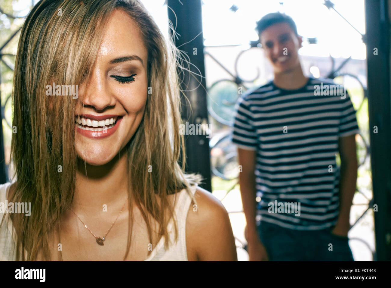 Woman laughing with boyfriend in background Stock Photo