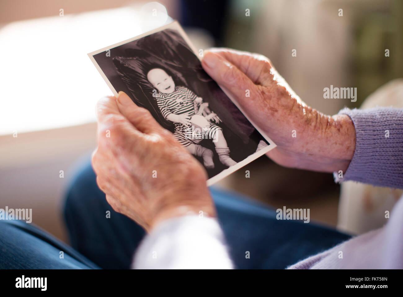 Caucasian woman admiring photograph of baby Stock Photo