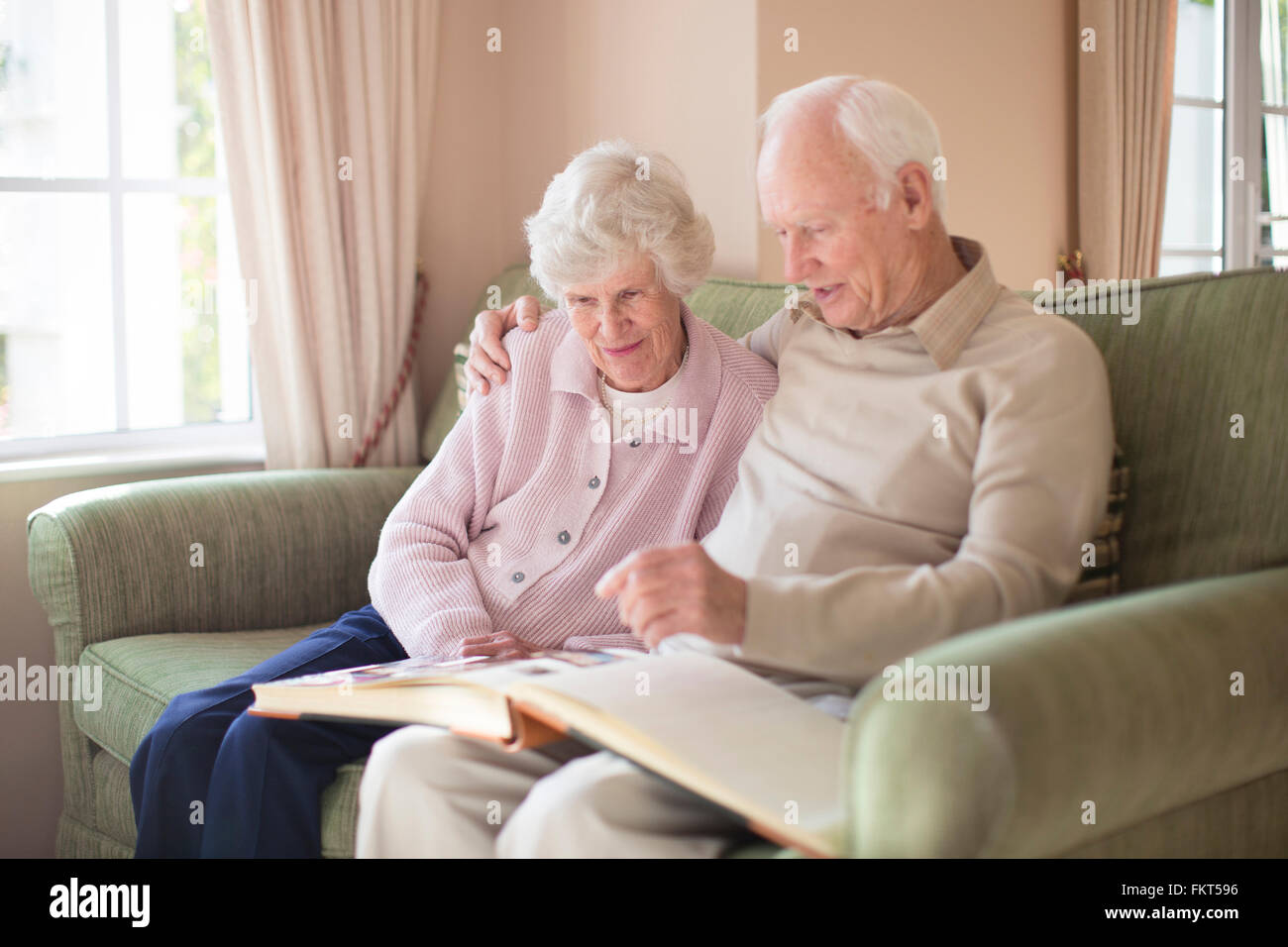 Older Caucasian couple looking at photo album Stock Photo