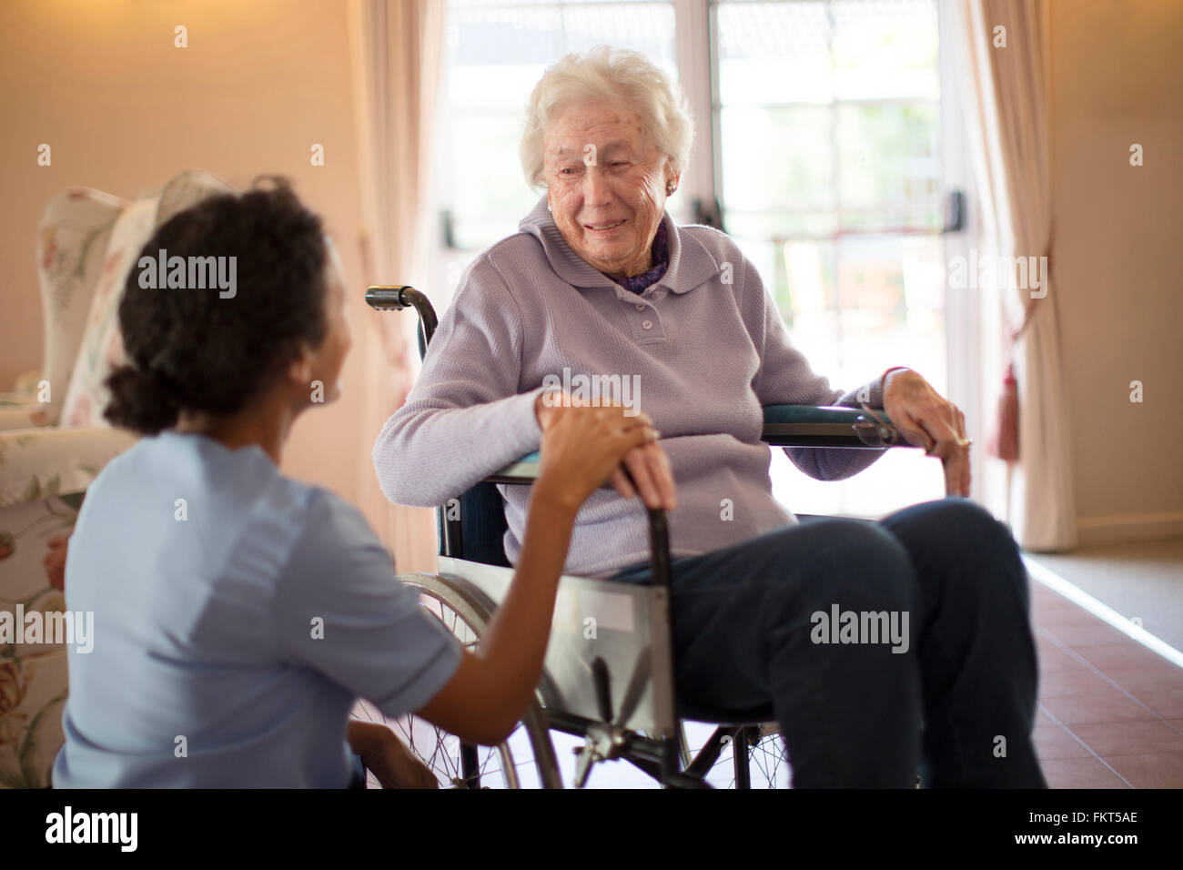 Nurse talking to patient in wheelchair Stock Photo