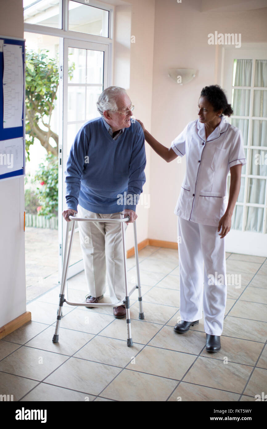 Nurse talking to patient using walker Stock Photo